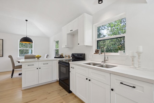 kitchen featuring pendant lighting, electric range, sink, and a healthy amount of sunlight