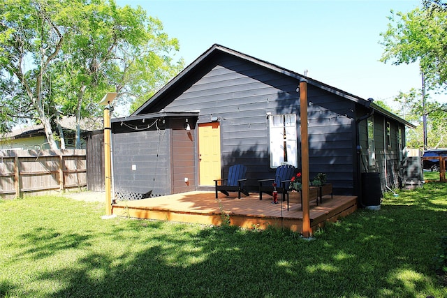 rear view of property with a yard and a deck