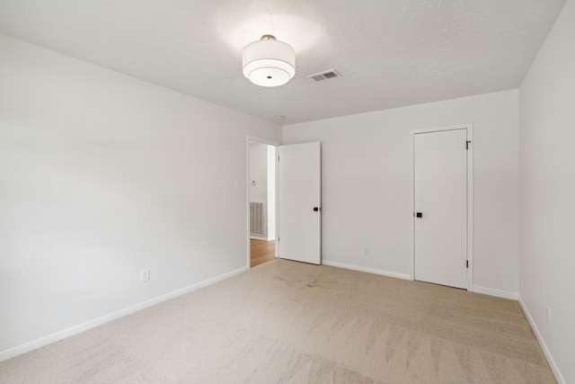 unfurnished bedroom featuring a closet and light colored carpet