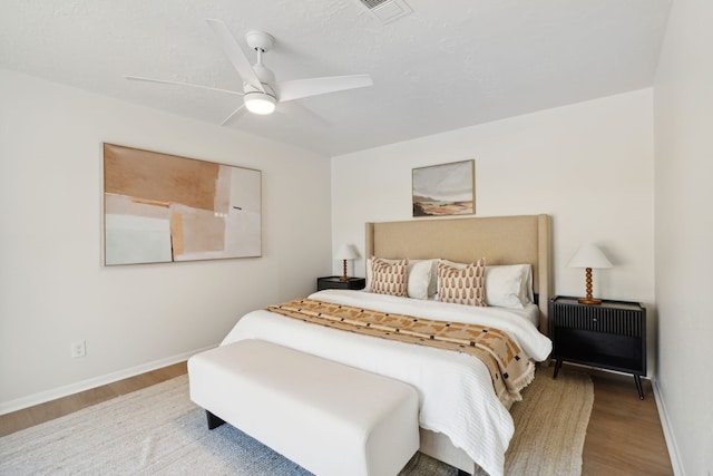 bedroom with ceiling fan, a textured ceiling, and hardwood / wood-style flooring