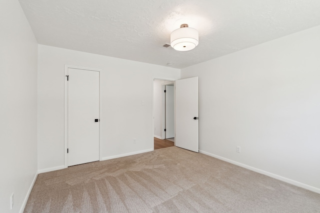 carpeted spare room featuring a textured ceiling