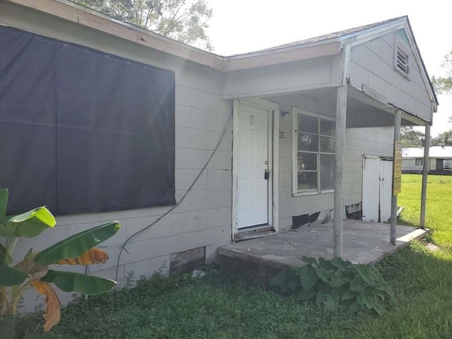 view of exterior entry featuring a yard