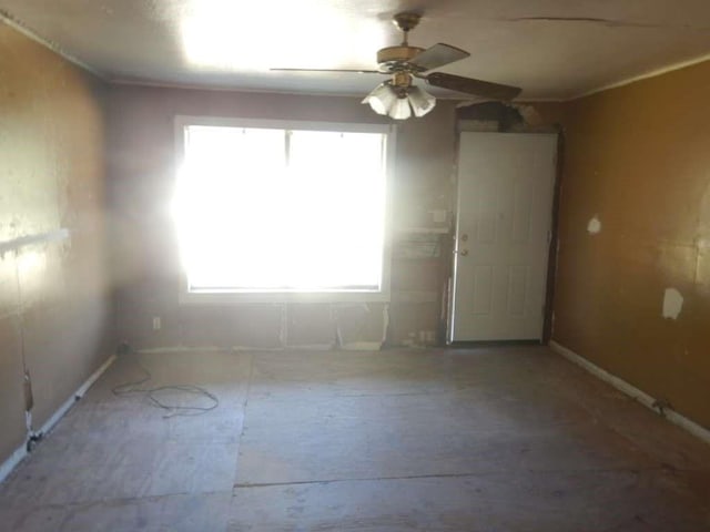 empty room with ceiling fan and plenty of natural light