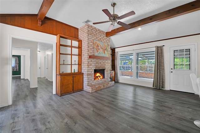 unfurnished living room with lofted ceiling with beams, ceiling fan, a textured ceiling, a fireplace, and dark hardwood / wood-style flooring