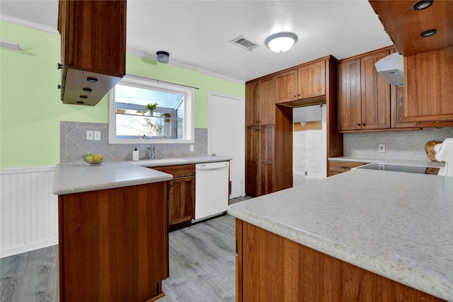 kitchen with exhaust hood, decorative backsplash, white dishwasher, and light hardwood / wood-style floors