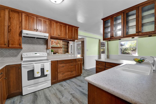 kitchen featuring decorative backsplash, light wood-type flooring, white electric stove, and sink