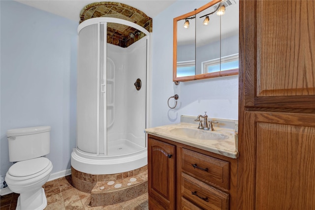 bathroom featuring vanity, an enclosed shower, and toilet