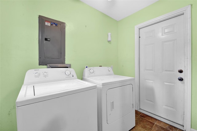 laundry room with electric panel, dark tile patterned floors, and washer and dryer