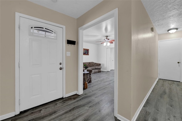 foyer entrance with ceiling fan, wood-type flooring, and a textured ceiling