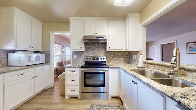 kitchen with electric stove, white cabinetry, and sink