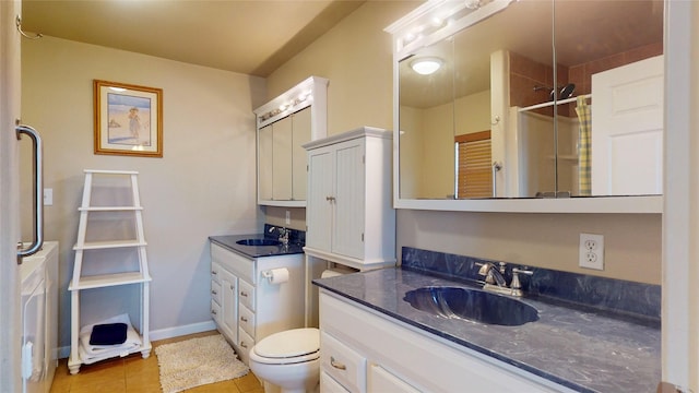 bathroom with tile patterned floors, vanity, a tile shower, and toilet