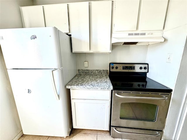 kitchen with white cabinetry, white fridge, light tile patterned flooring, and stainless steel electric range