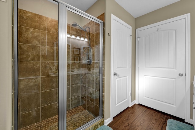 bathroom with hardwood / wood-style floors and a shower with shower door