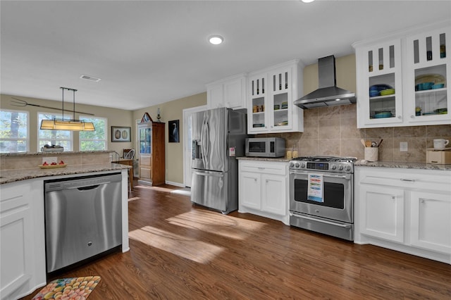 kitchen with white cabinets, dark hardwood / wood-style floors, wall chimney range hood, and stainless steel appliances