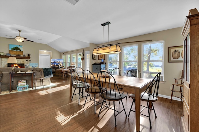 dining room featuring a fireplace, dark hardwood / wood-style floors, plenty of natural light, and lofted ceiling