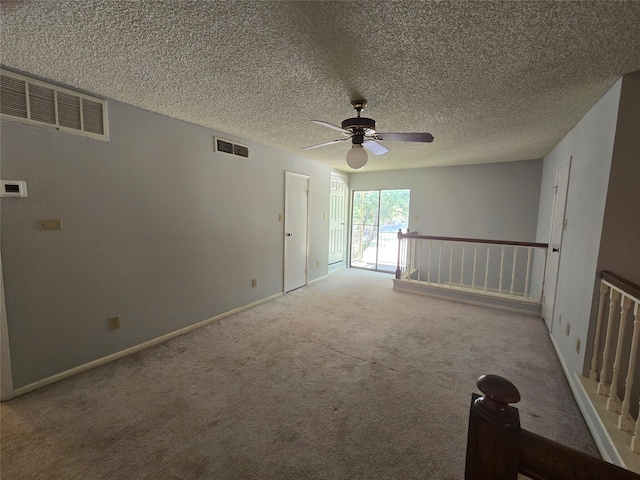 empty room featuring carpet, a textured ceiling, and ceiling fan