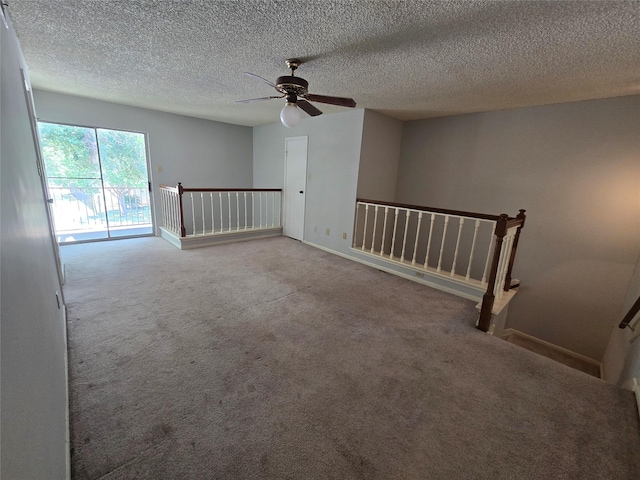 carpeted spare room featuring ceiling fan and a textured ceiling