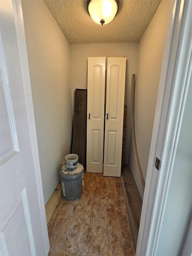 interior space featuring dark colored carpet and a textured ceiling