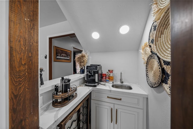 bathroom featuring vanity and lofted ceiling