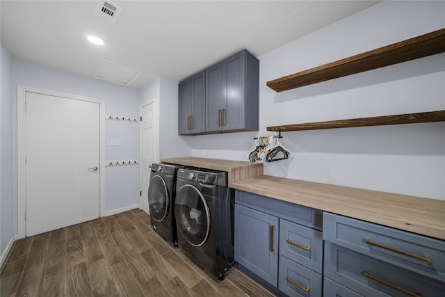 laundry room featuring cabinets, dark wood-type flooring, and washing machine and clothes dryer