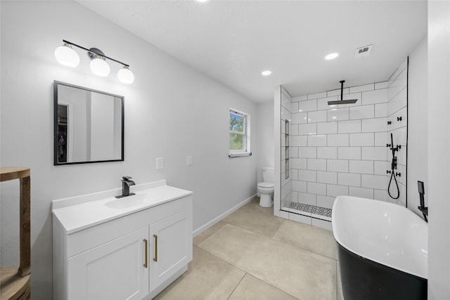 bathroom with tile patterned flooring, vanity, tiled shower, and toilet