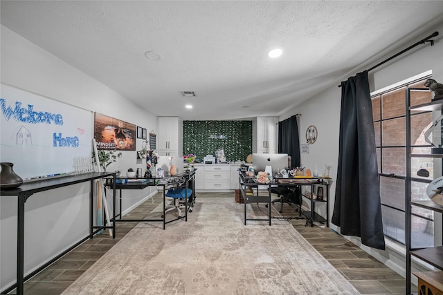 office with wood-type flooring and a textured ceiling