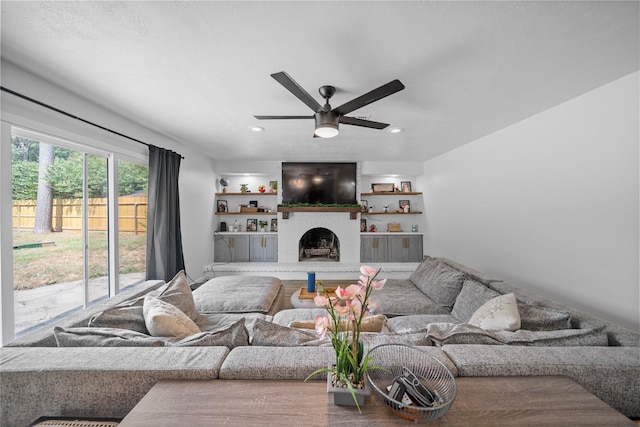 living room with a brick fireplace and ceiling fan