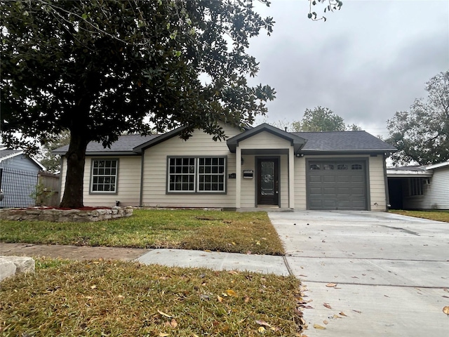 ranch-style home with a garage and a front lawn