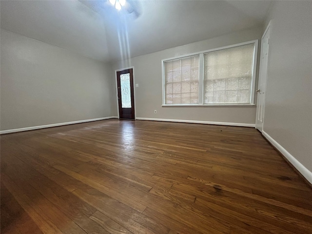 empty room with ceiling fan and dark wood-type flooring