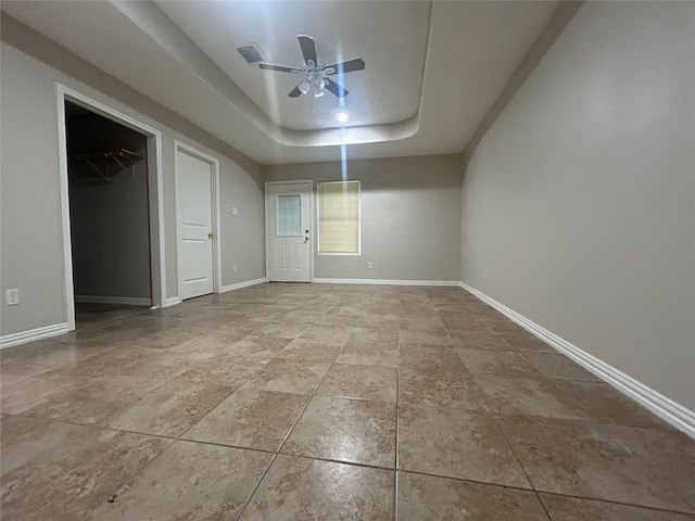 unfurnished bedroom with a tray ceiling and ceiling fan