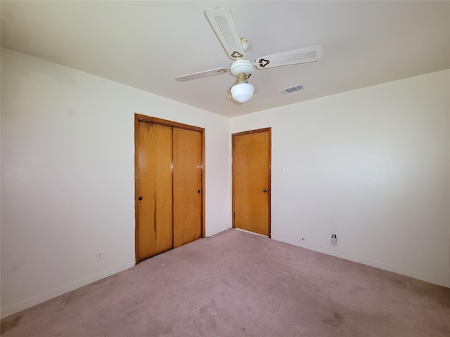 unfurnished bedroom with ceiling fan, light carpet, and a closet