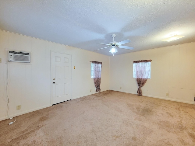 unfurnished room featuring light carpet, a textured ceiling, a wall mounted AC, and ceiling fan