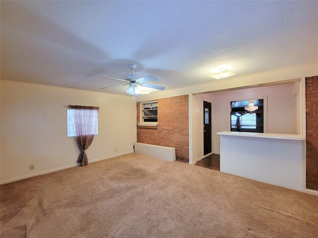 carpeted empty room with a textured ceiling, ceiling fan, and ornamental molding