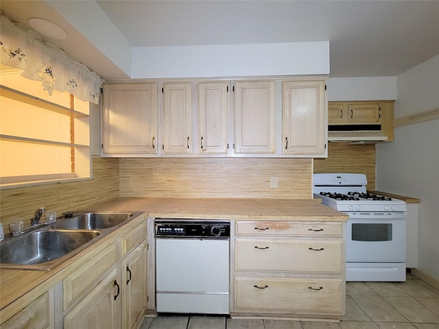 kitchen with tasteful backsplash, sink, light tile patterned floors, and white appliances