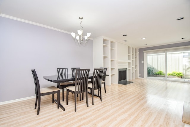 dining area with light hardwood / wood-style flooring, an inviting chandelier, and ornamental molding