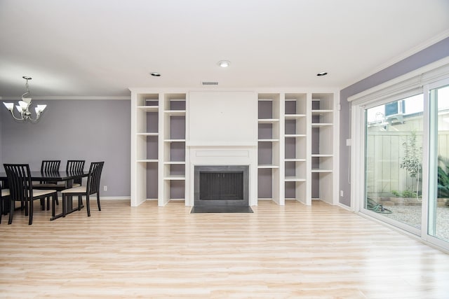 living room featuring crown molding, a chandelier, and light wood-type flooring