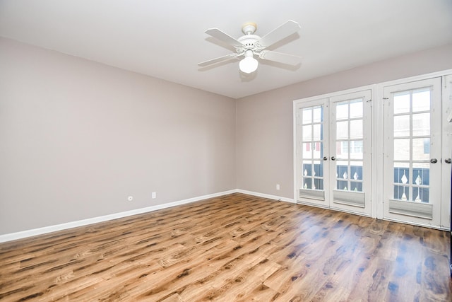 empty room with ceiling fan, light hardwood / wood-style floors, and french doors