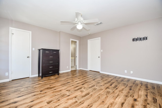 unfurnished bedroom featuring ceiling fan, light wood-type flooring, and connected bathroom