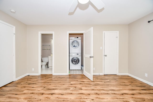 foyer entrance with ceiling fan, stacked washing maching and dryer, and light wood-type flooring