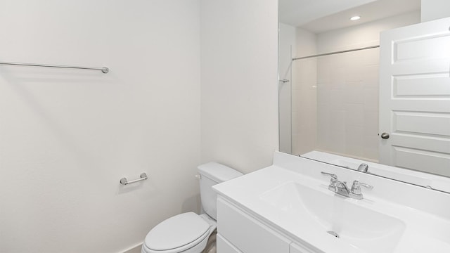 bathroom featuring vanity, toilet, and a shower