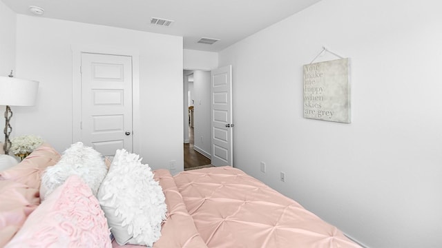 bedroom with dark hardwood / wood-style flooring and a closet