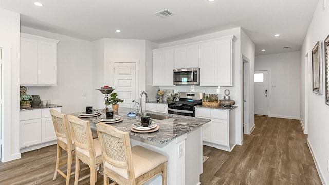 kitchen featuring white cabinetry, a kitchen island with sink, and appliances with stainless steel finishes