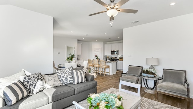 living room featuring ceiling fan and dark wood-type flooring