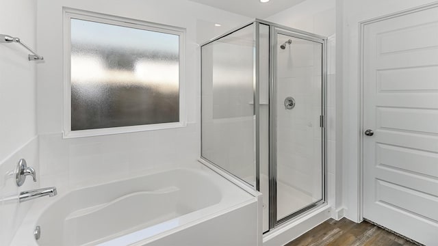 bathroom with independent shower and bath and hardwood / wood-style flooring