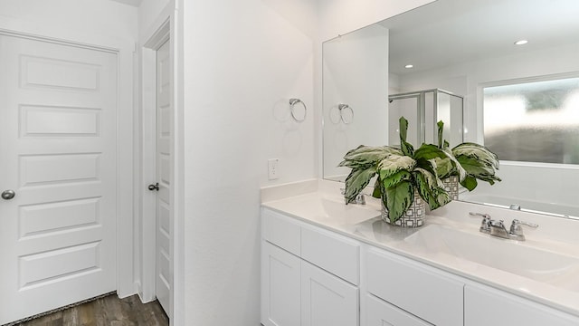 bathroom featuring hardwood / wood-style floors, vanity, and walk in shower