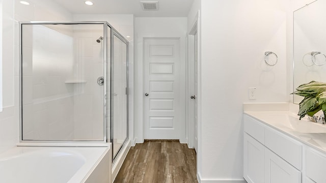 bathroom featuring vanity, wood-type flooring, and shower with separate bathtub