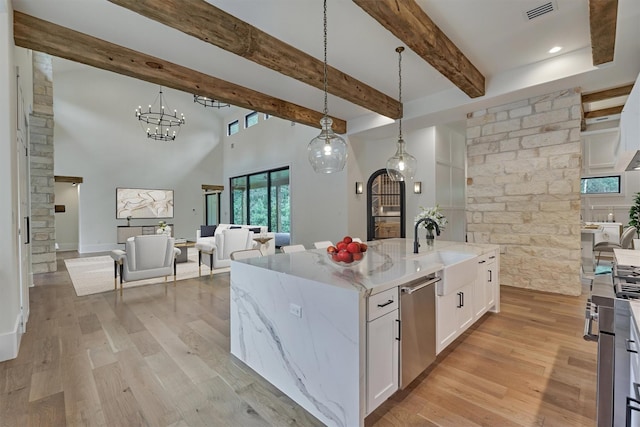 kitchen featuring dishwasher, a center island with sink, white cabinets, and pendant lighting