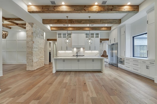 kitchen featuring decorative light fixtures, light hardwood / wood-style floors, stainless steel appliances, and decorative columns