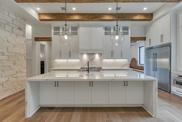 kitchen featuring stainless steel appliances, beam ceiling, light hardwood / wood-style floors, hanging light fixtures, and a large island