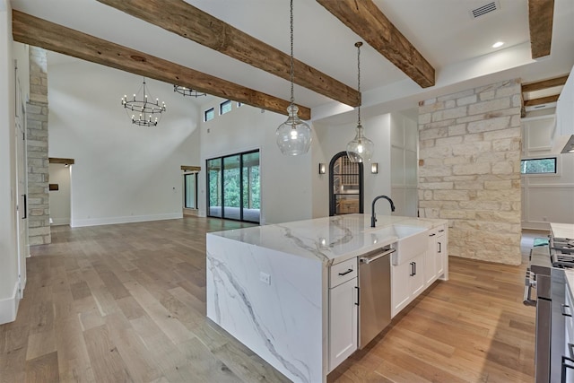 kitchen featuring a large island with sink, dishwasher, white cabinets, and pendant lighting